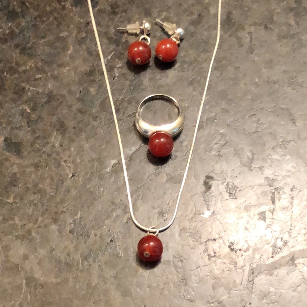 Beautiful silver jewelry set (chain, pendant, ring, earings) with red stones.